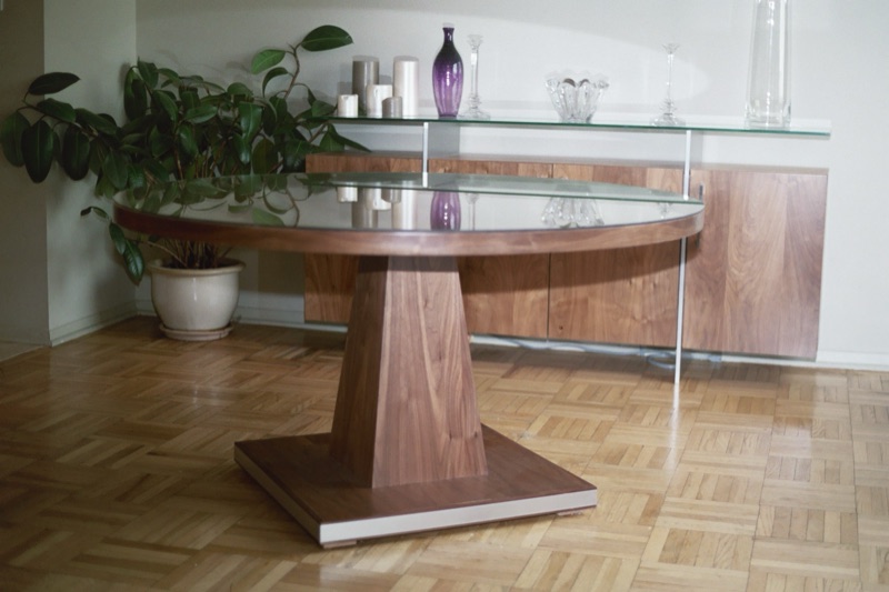 Round walnut pedestal dining table on a parquet floor, custom made by Van Aken Design