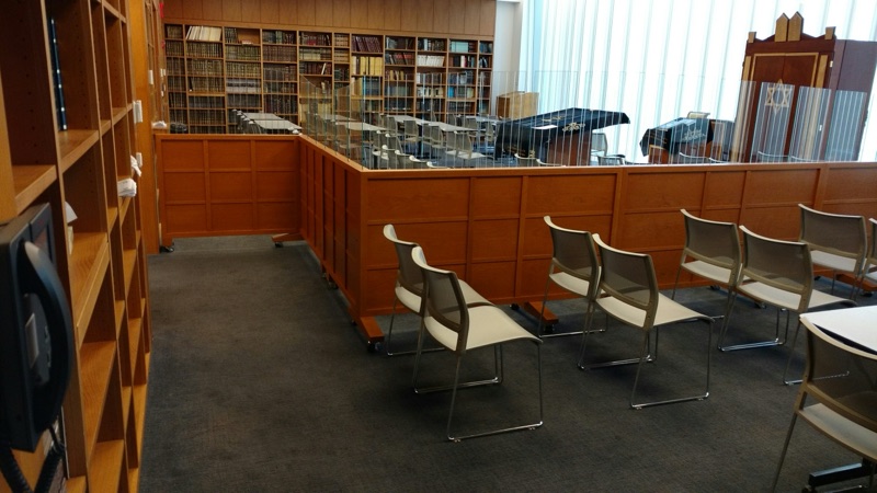 Warm cherry-toned bookcases and low cabinetry in a synagogue study hall, custom millwork by Van Aken Design